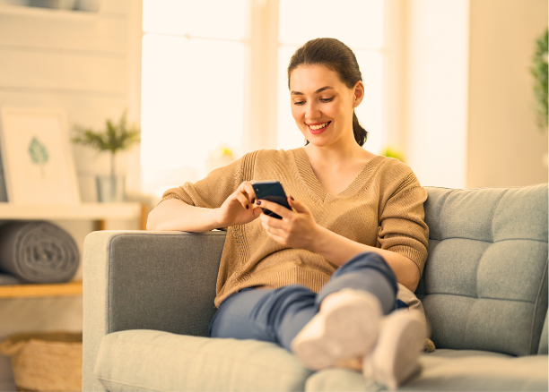 Vrouw vult op de bank de gezondheidstest in op haar telefoon